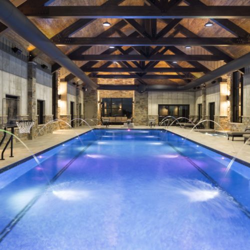 An indoor swimming pool in a building with wood beams.