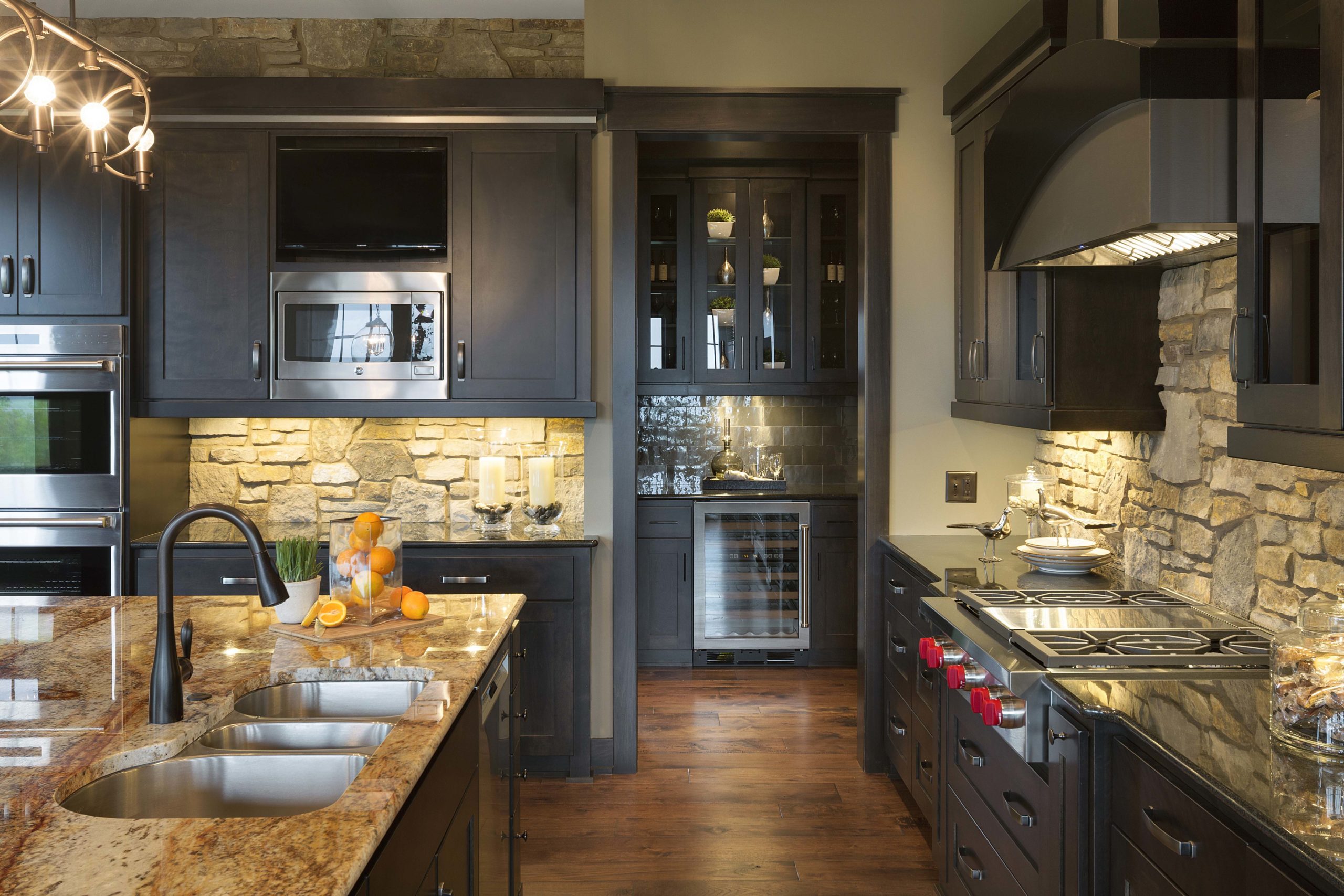A kitchen with black cabinets and granite counter tops.