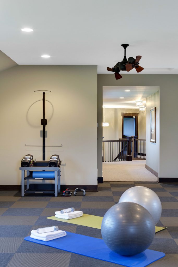 A home gym with exercise balls and a fan.