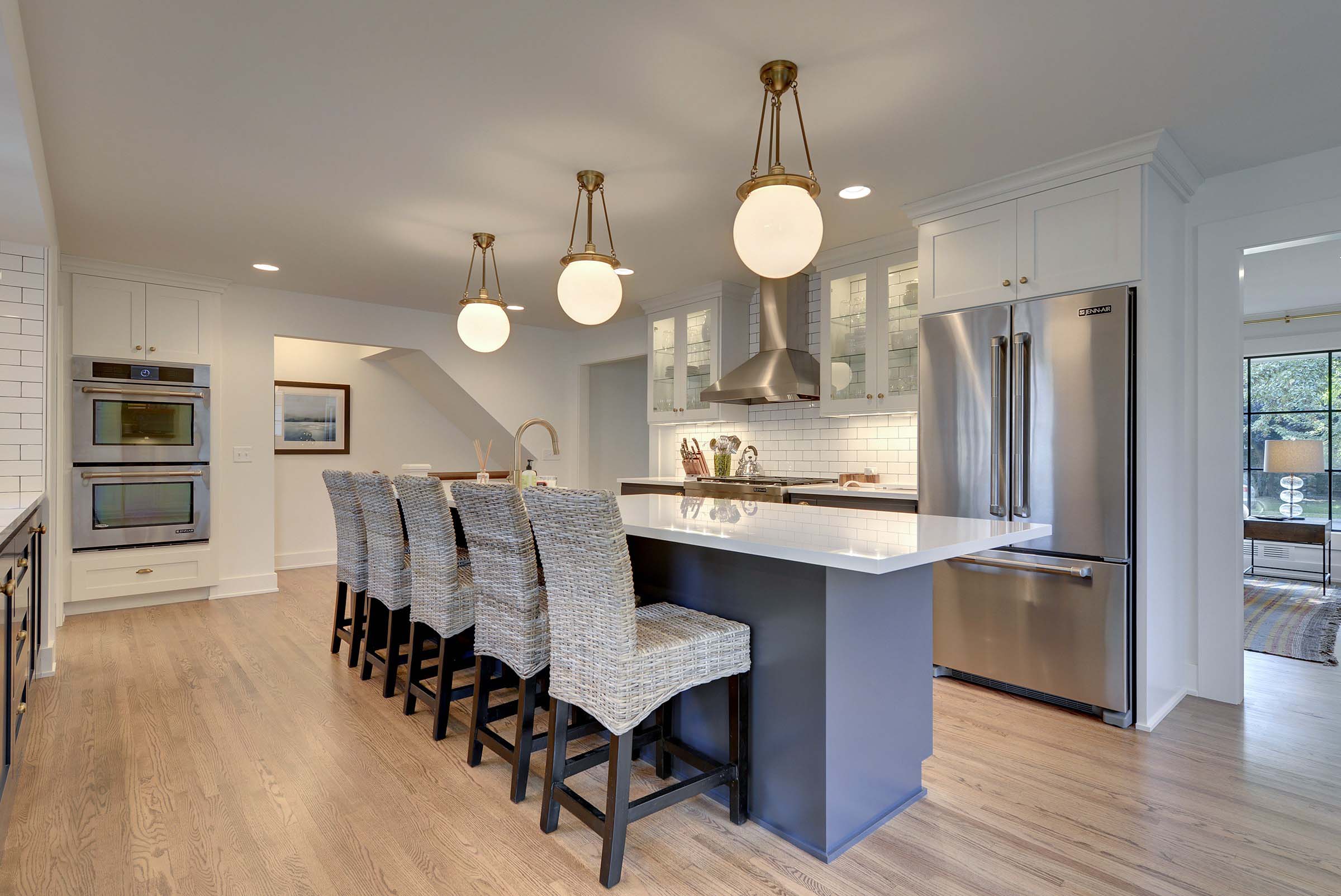 A kitchen with a center island and bar stools.