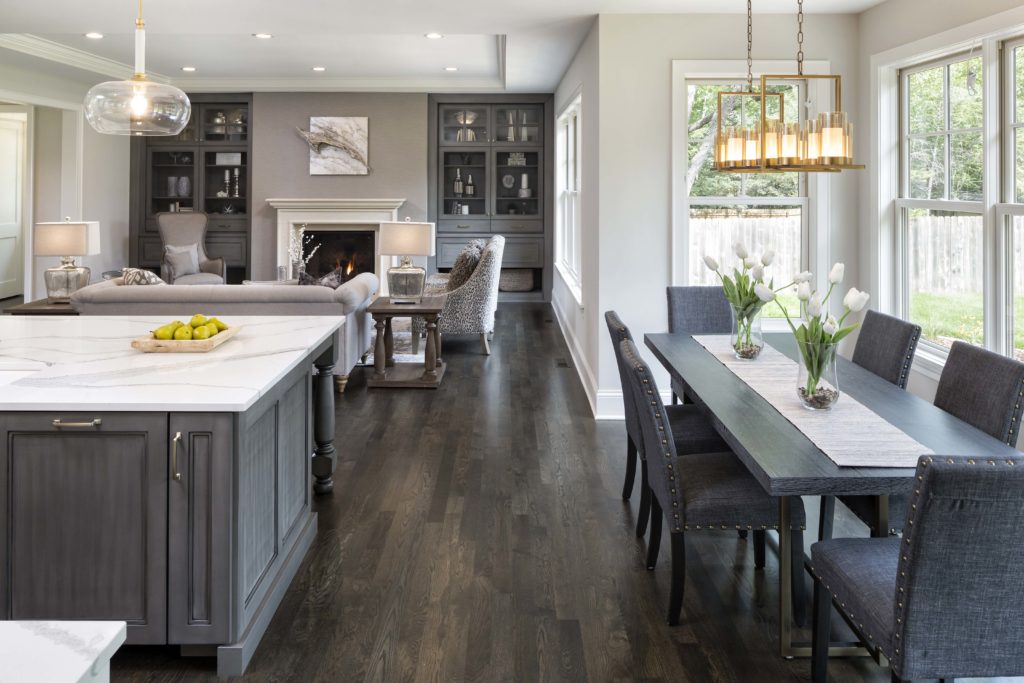 A gray kitchen with a dining table and chairs.