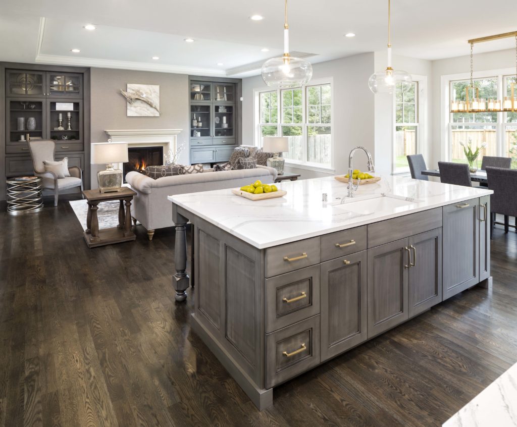 A kitchen with a large island and hardwood floors.