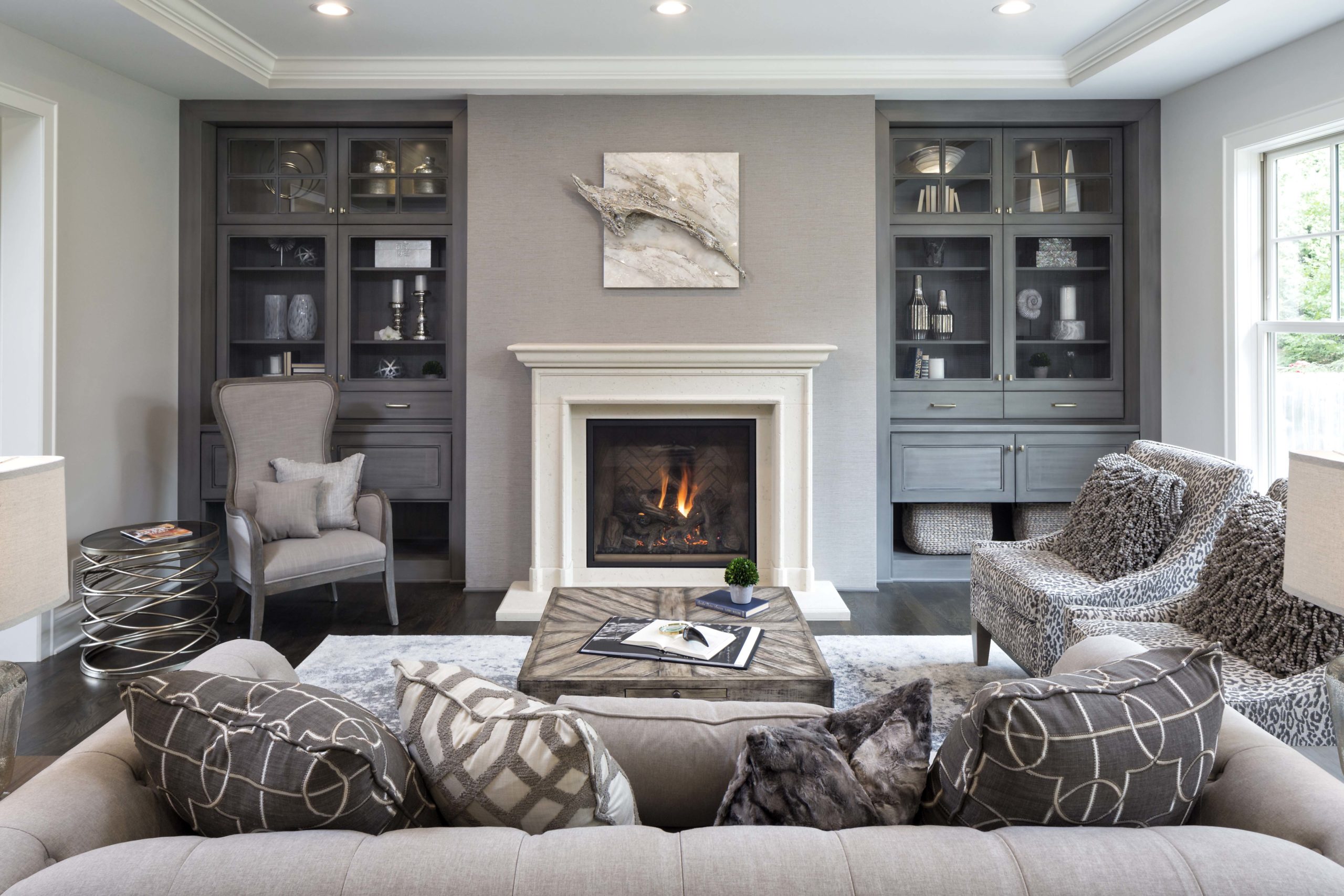 A living room with gray furniture and a fireplace.