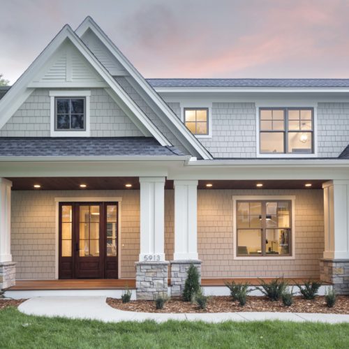 A home with a white front porch and gray siding.