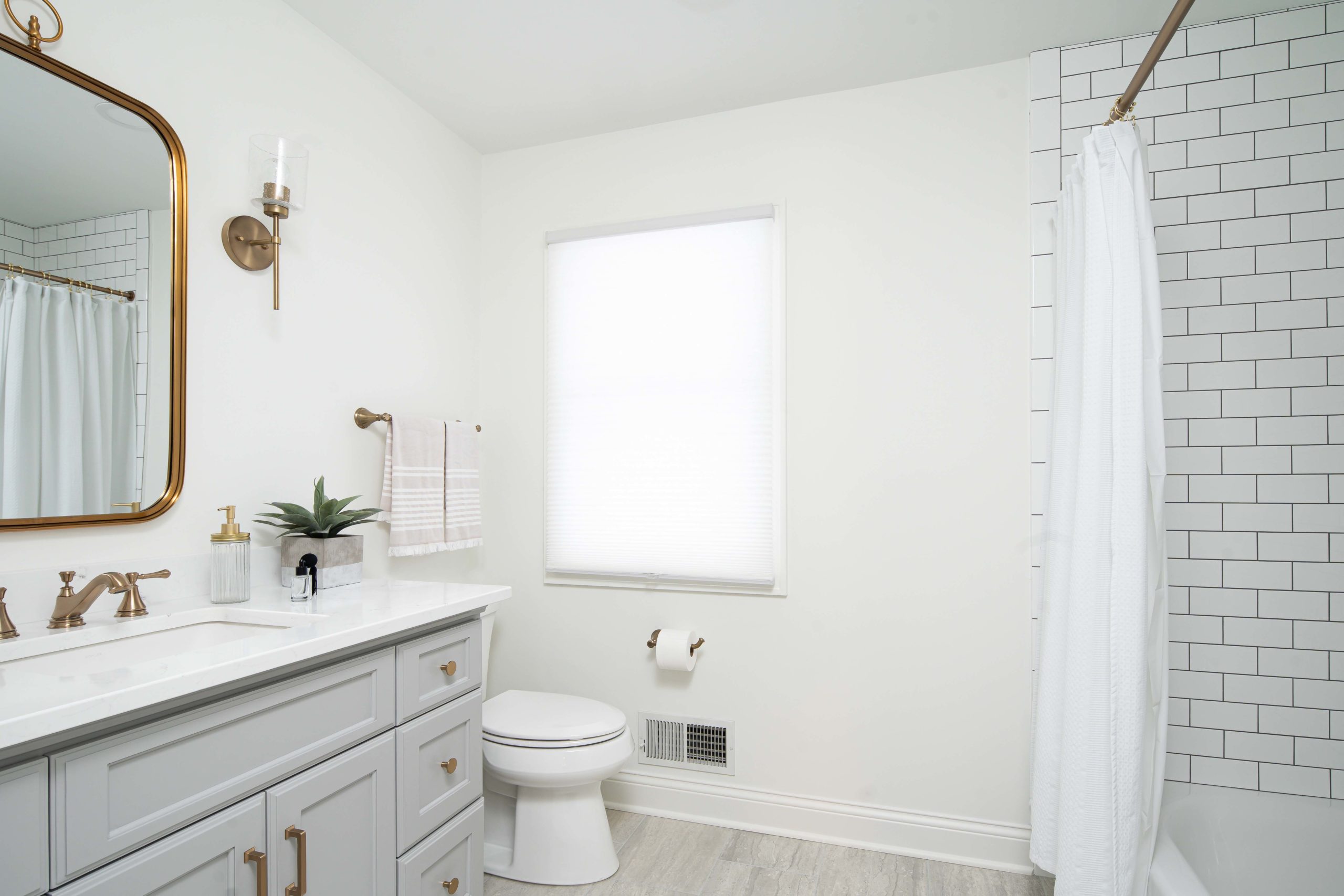 A white and gold bathroom with a toilet and sink, perfect for a kitchen remodel.