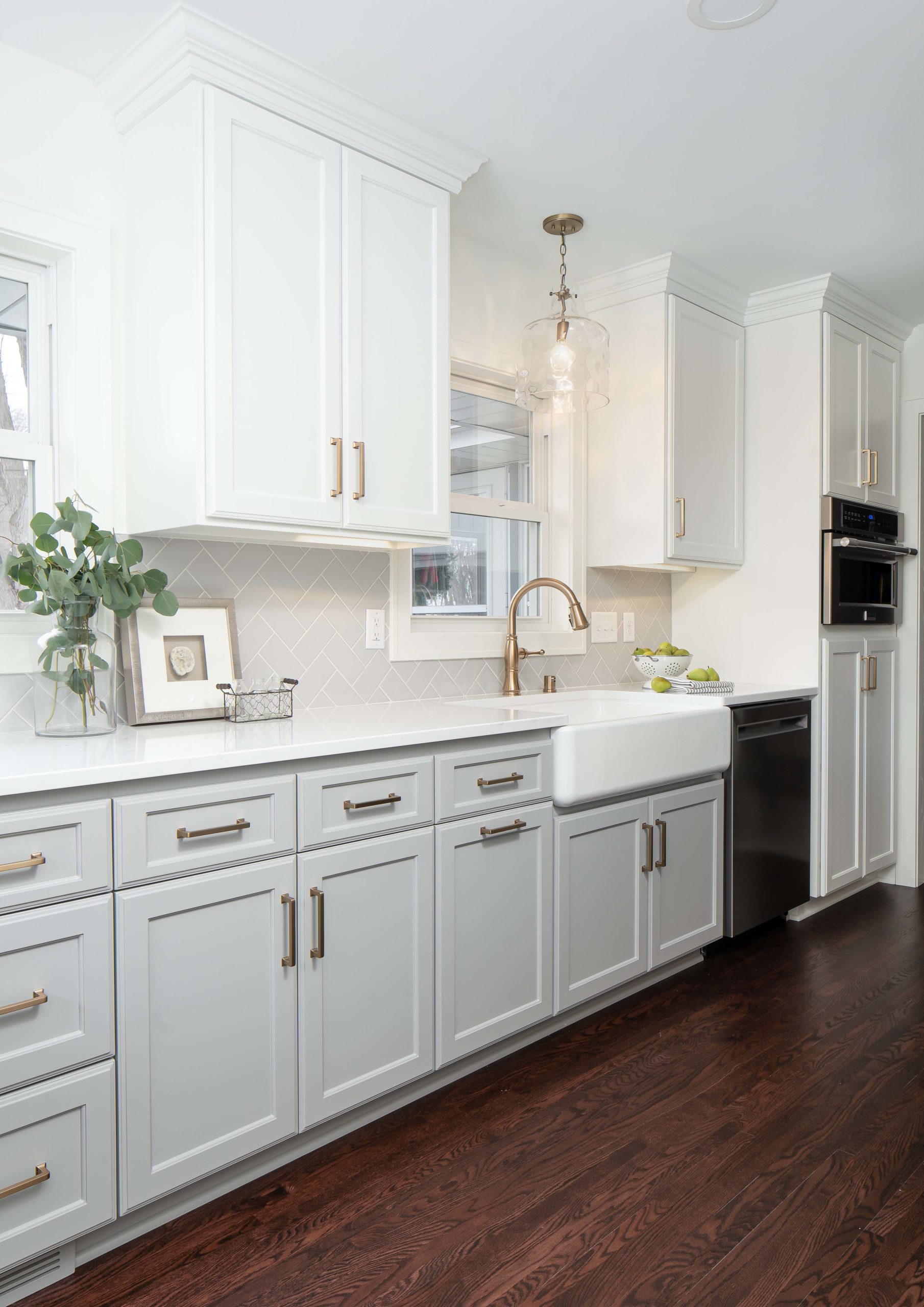 A kitchen renovation with white cabinets and hardwood floors.