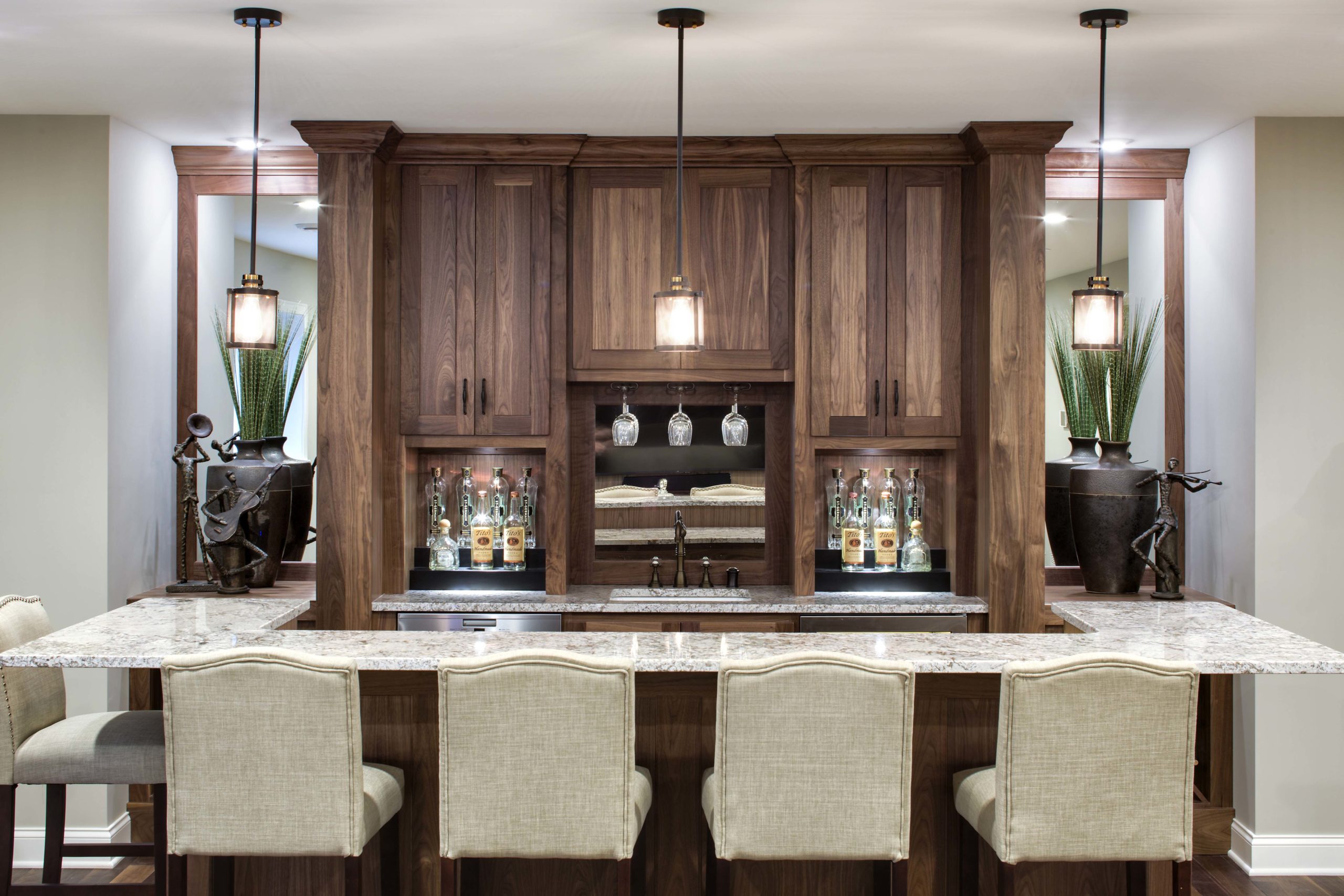 A modern kitchen with a bar and stools.