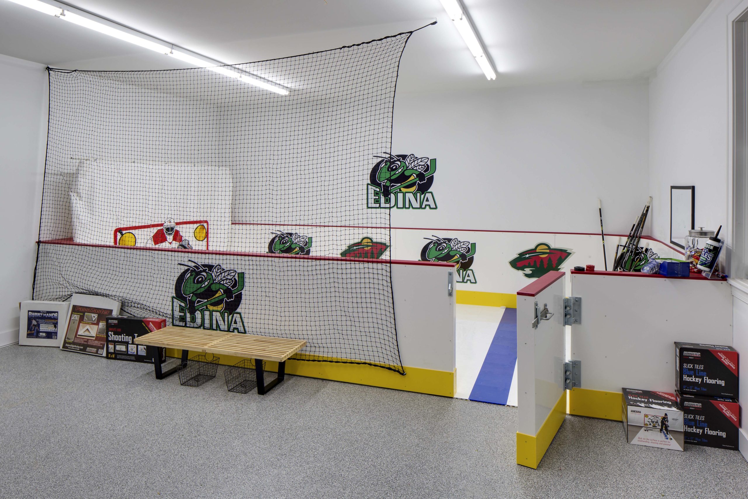 A hockey room with a bench and a net.