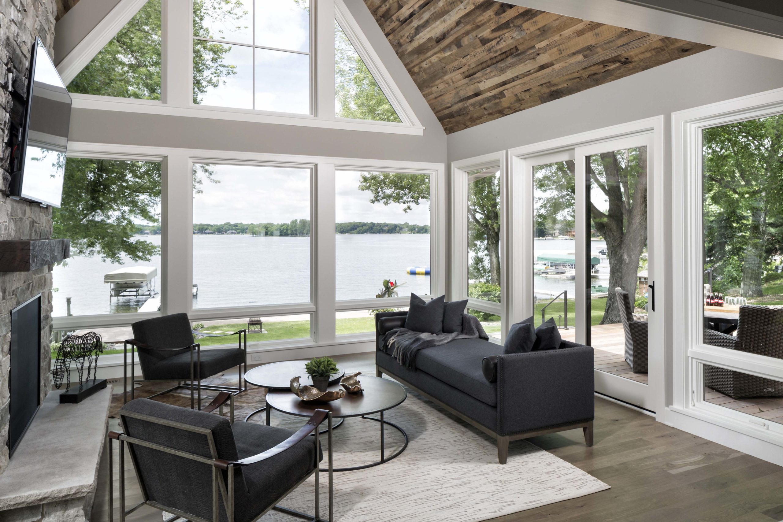 A living room with large windows overlooking a lake.