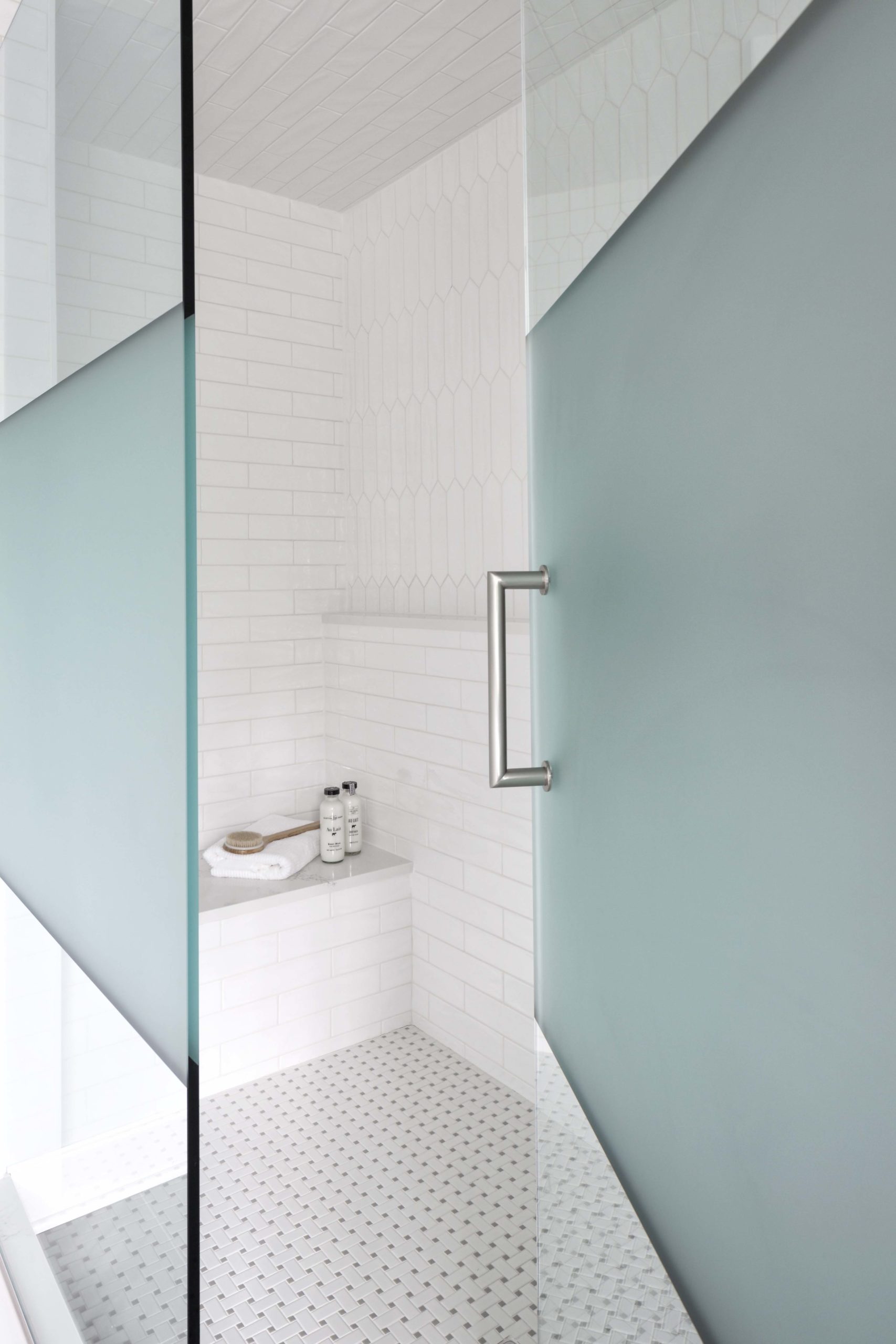 A white bathroom with a glass shower door.