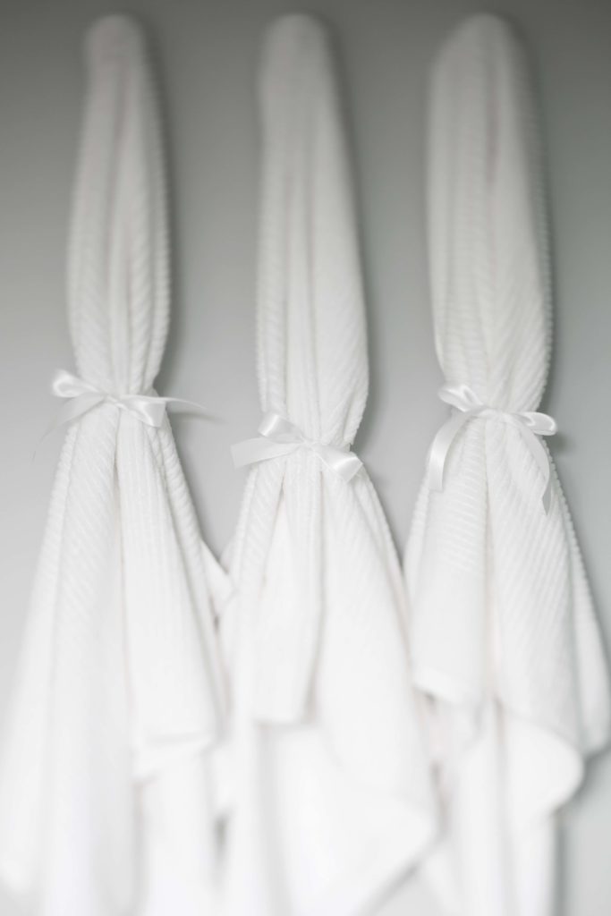 Three white towels with a bow tied around them.