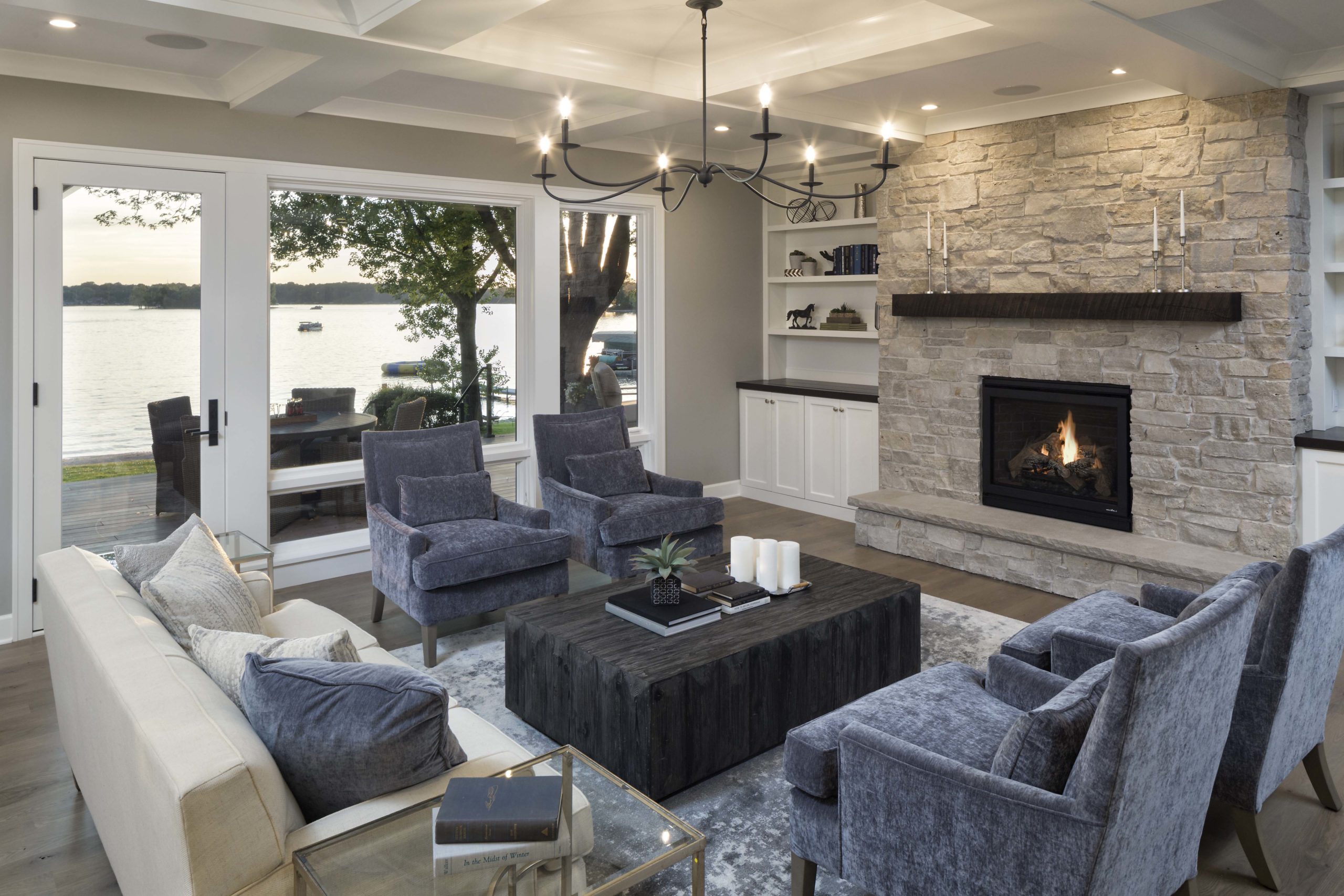 A living room with a fireplace and a view of the lake.