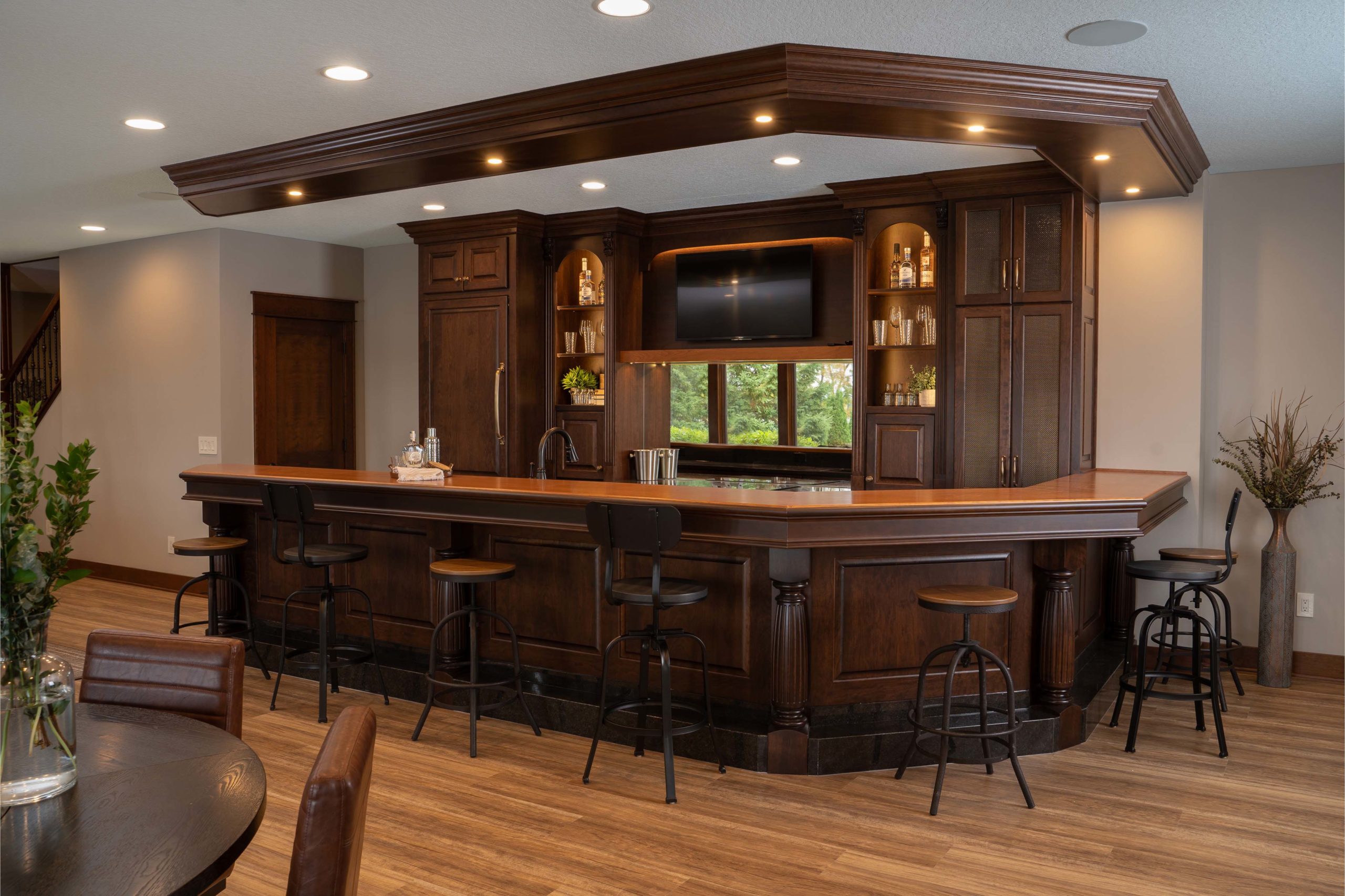A large kitchen with a bar and stools.
