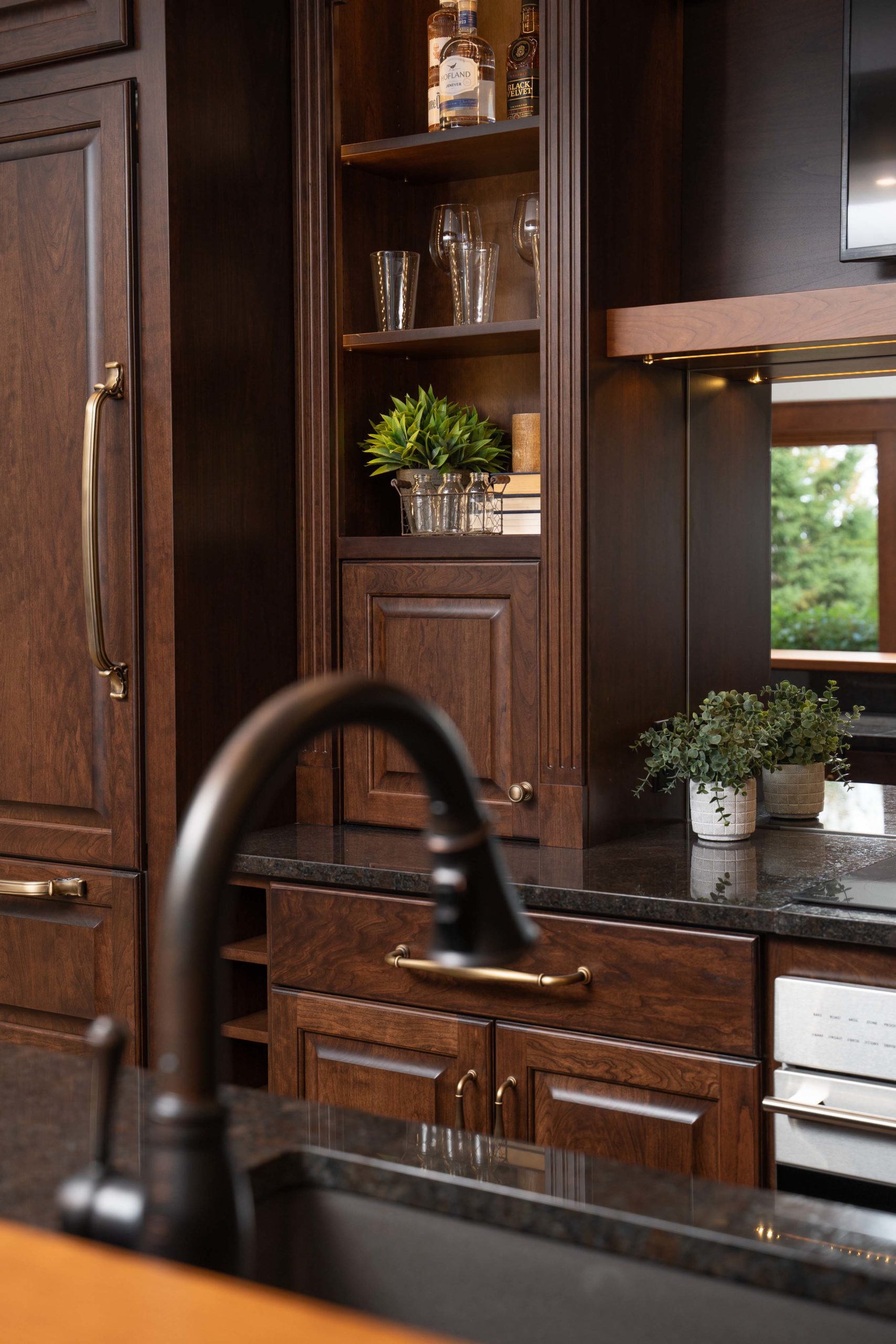 A kitchen with brown cabinets and a black sink.