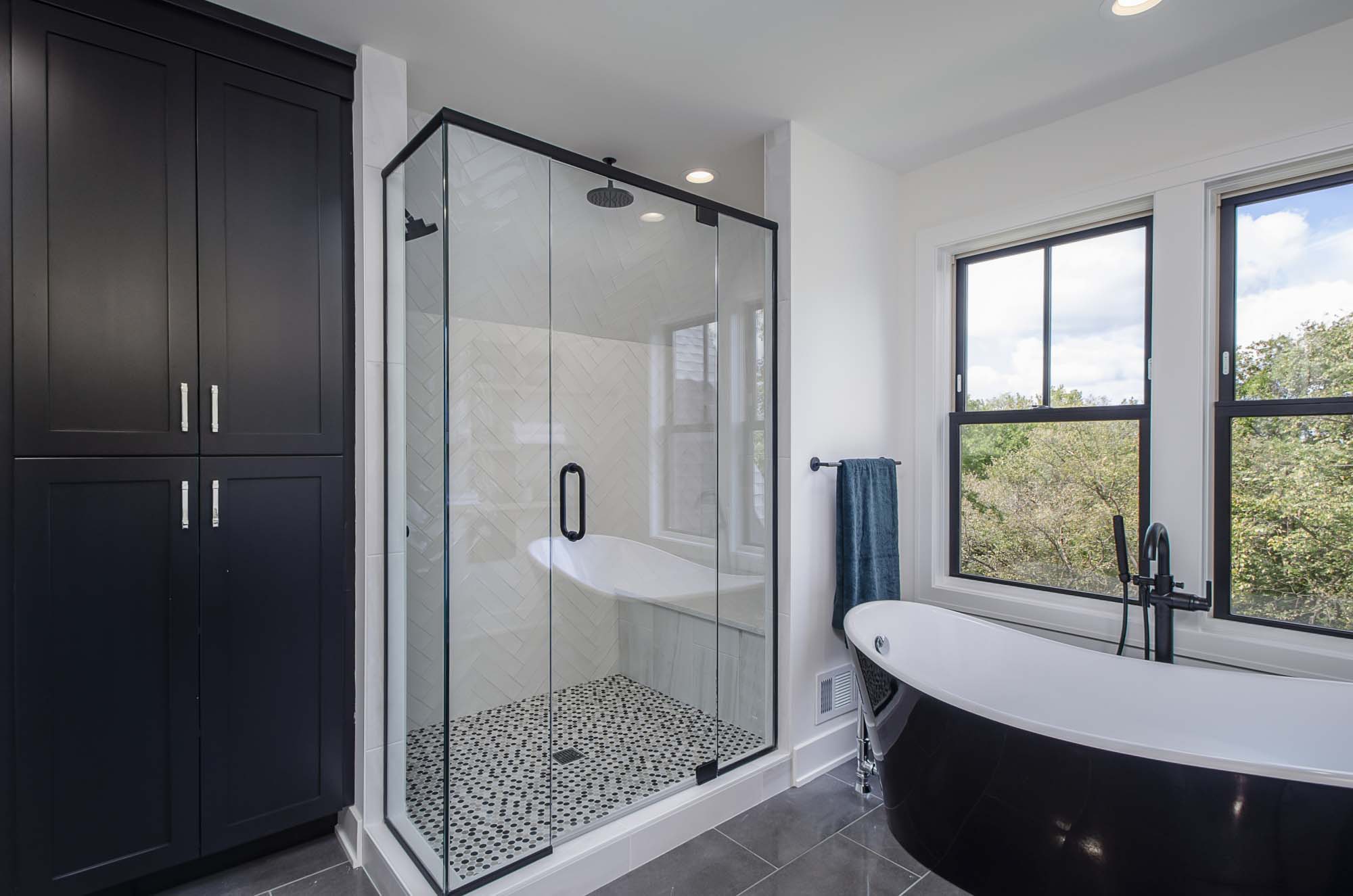 A black and white bathroom with a glass shower stall.