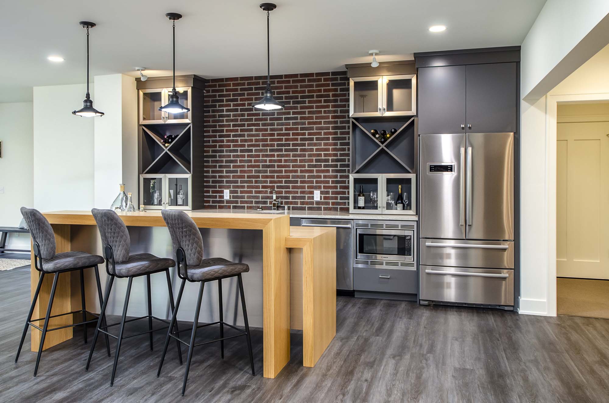 A kitchen with a brick wall and stainless steel appliances.