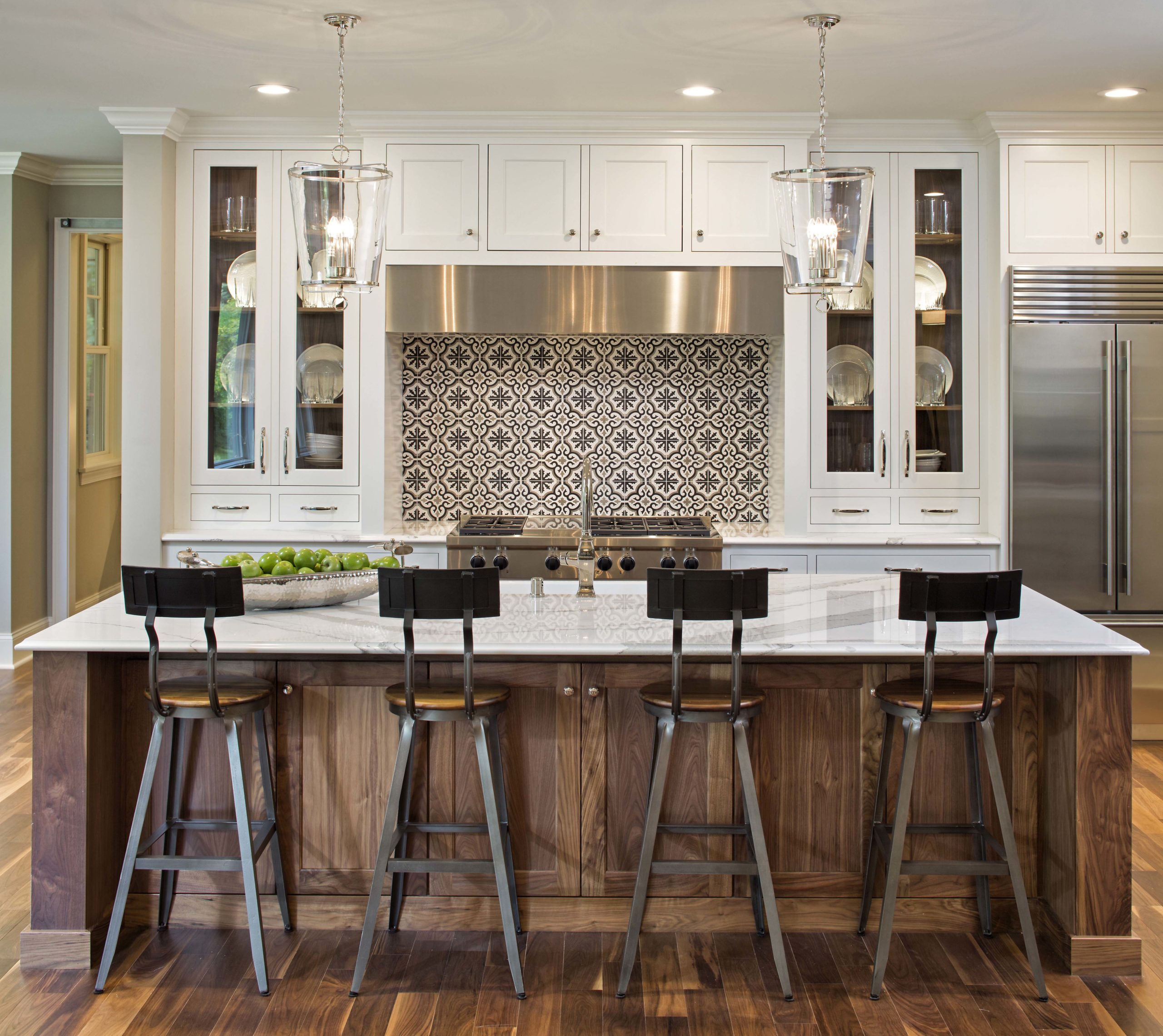 A kitchen with a center island and bar stools.