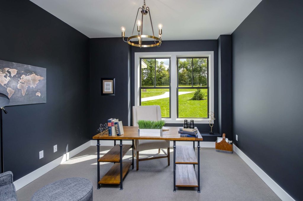 A home office with black walls and a desk.