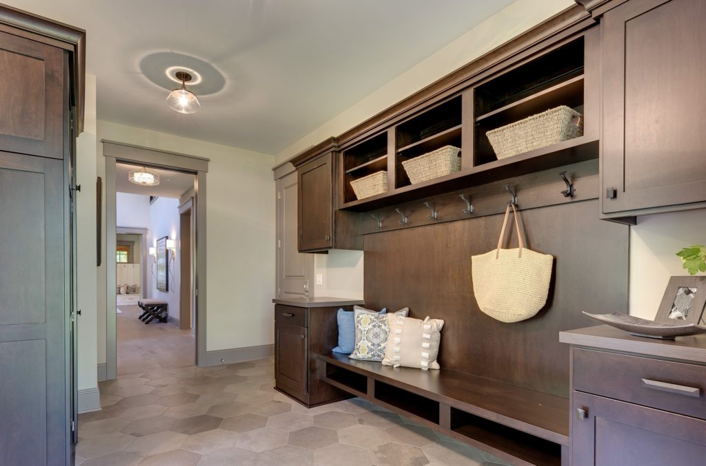 A mudroom with wooden cabinets and baskets.