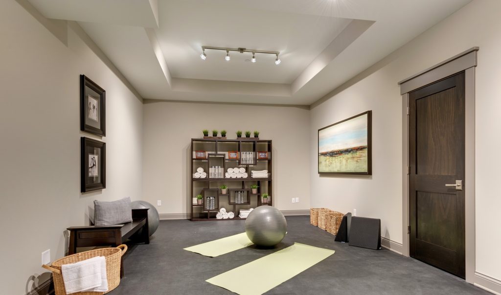 A home gym with a yoga mat and exercise equipment.