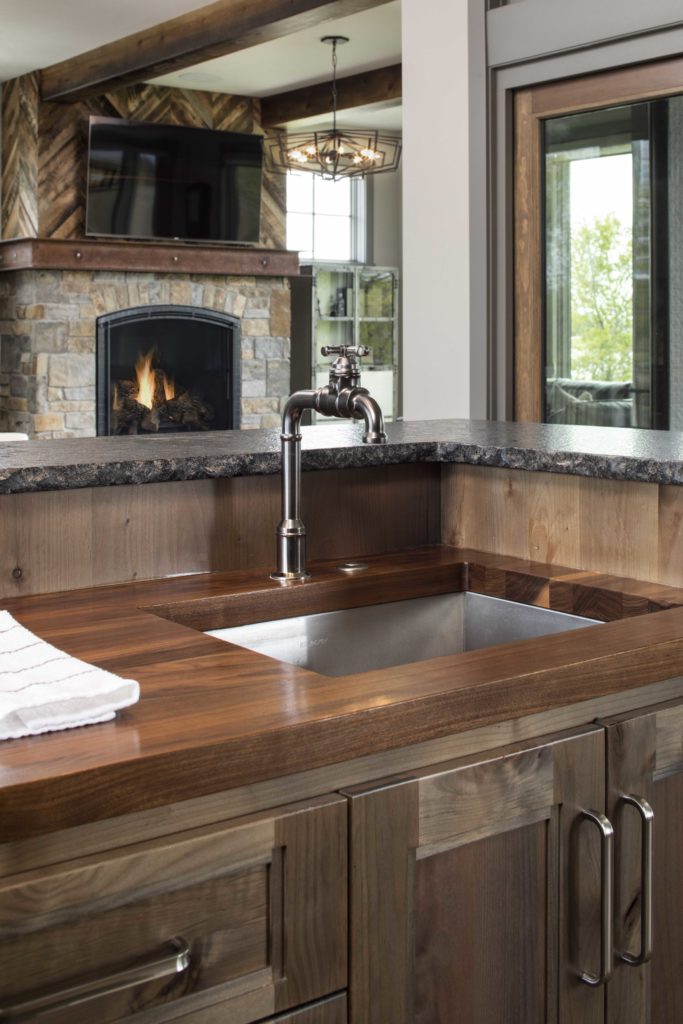 A kitchen with a wooden counter top and a fireplace.