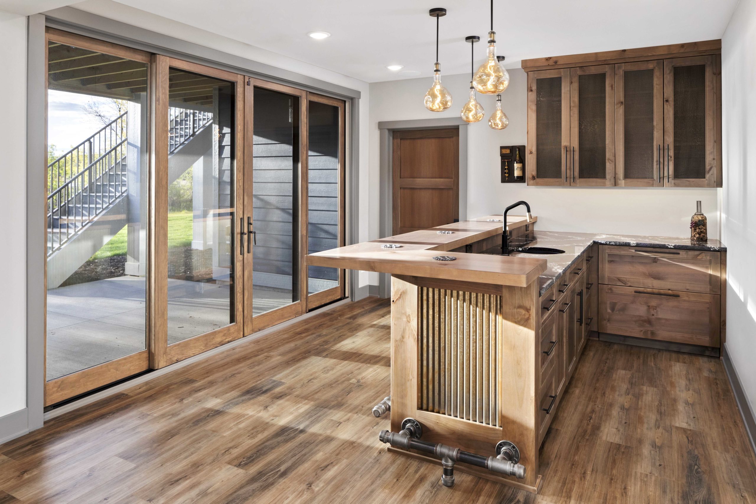 A kitchen with wood floors and sliding glass doors.