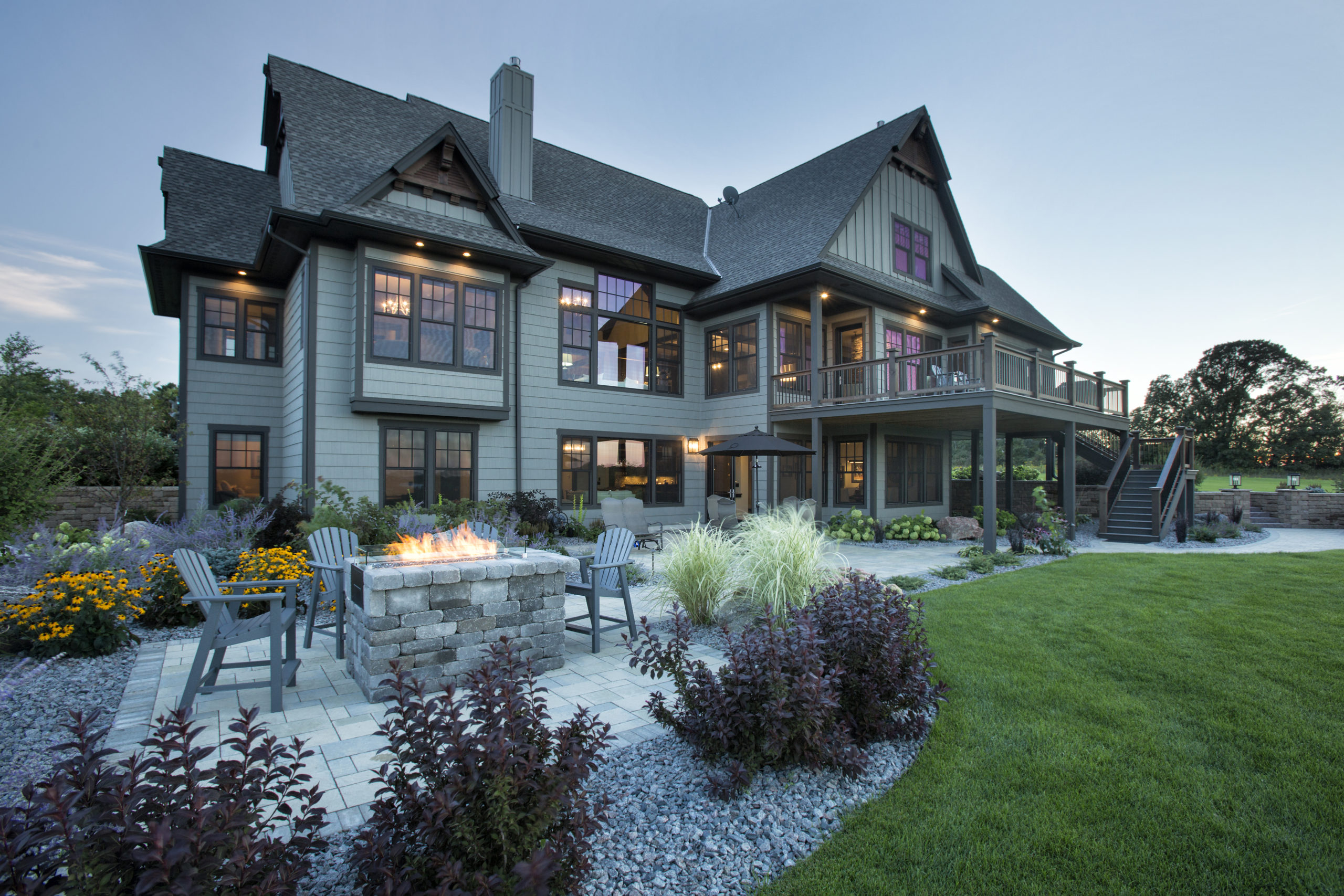 A large home with a fire pit in the yard.