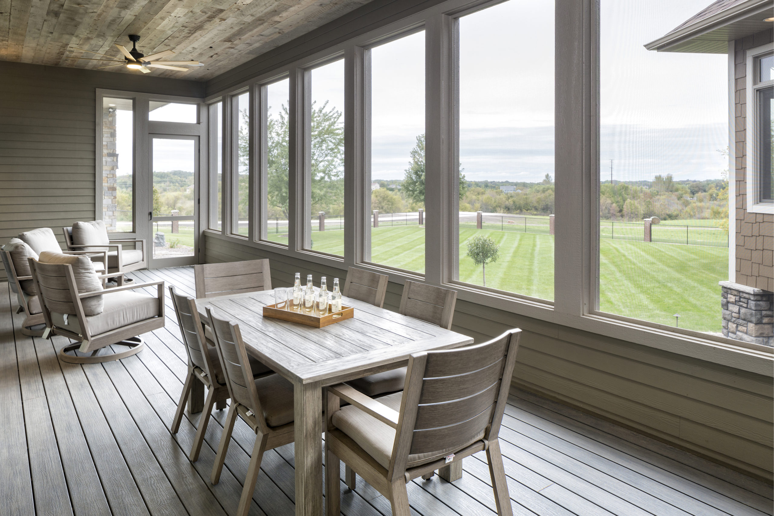 A screened in porch with a table and chairs.