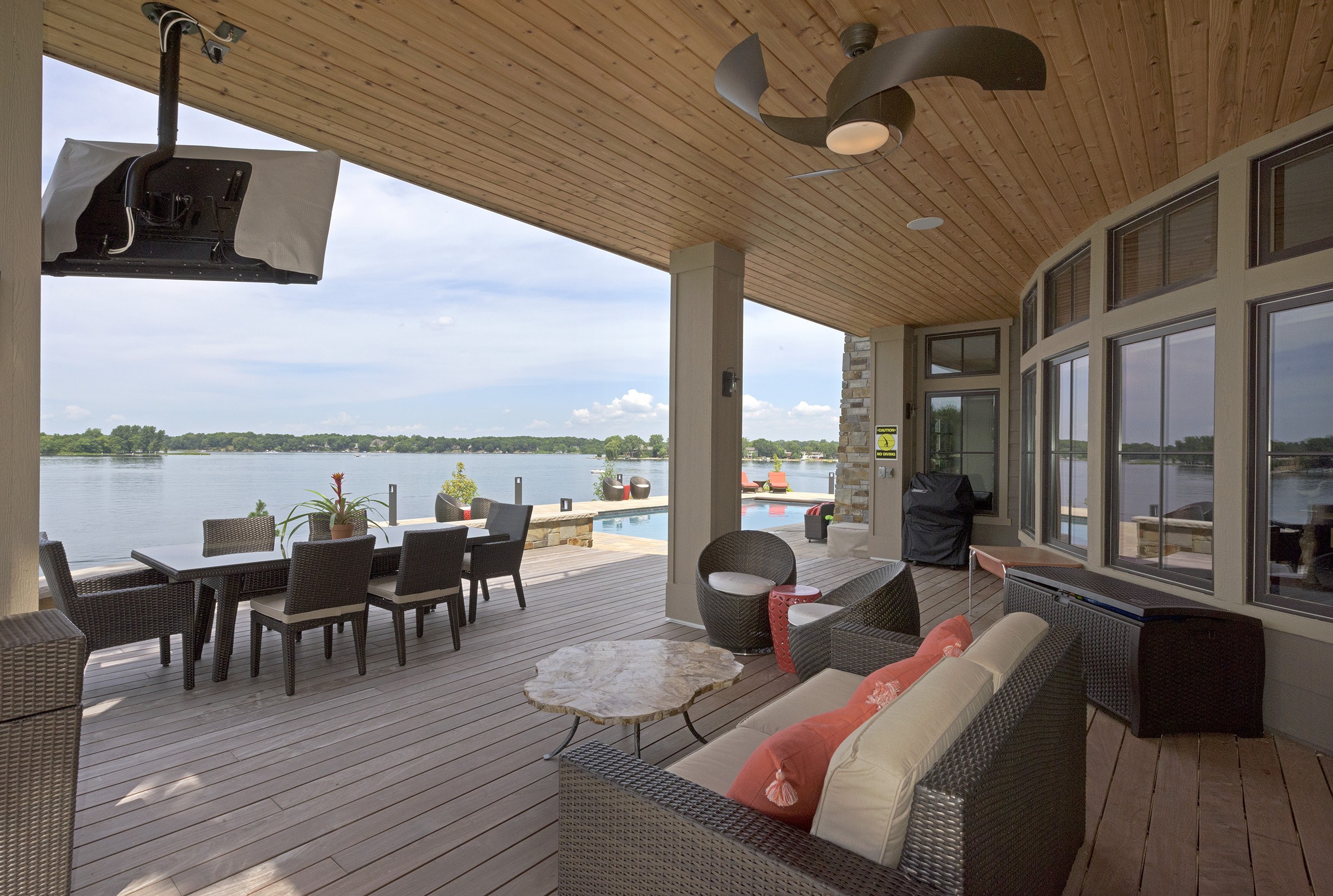 A deck with furniture and a view of a lake.