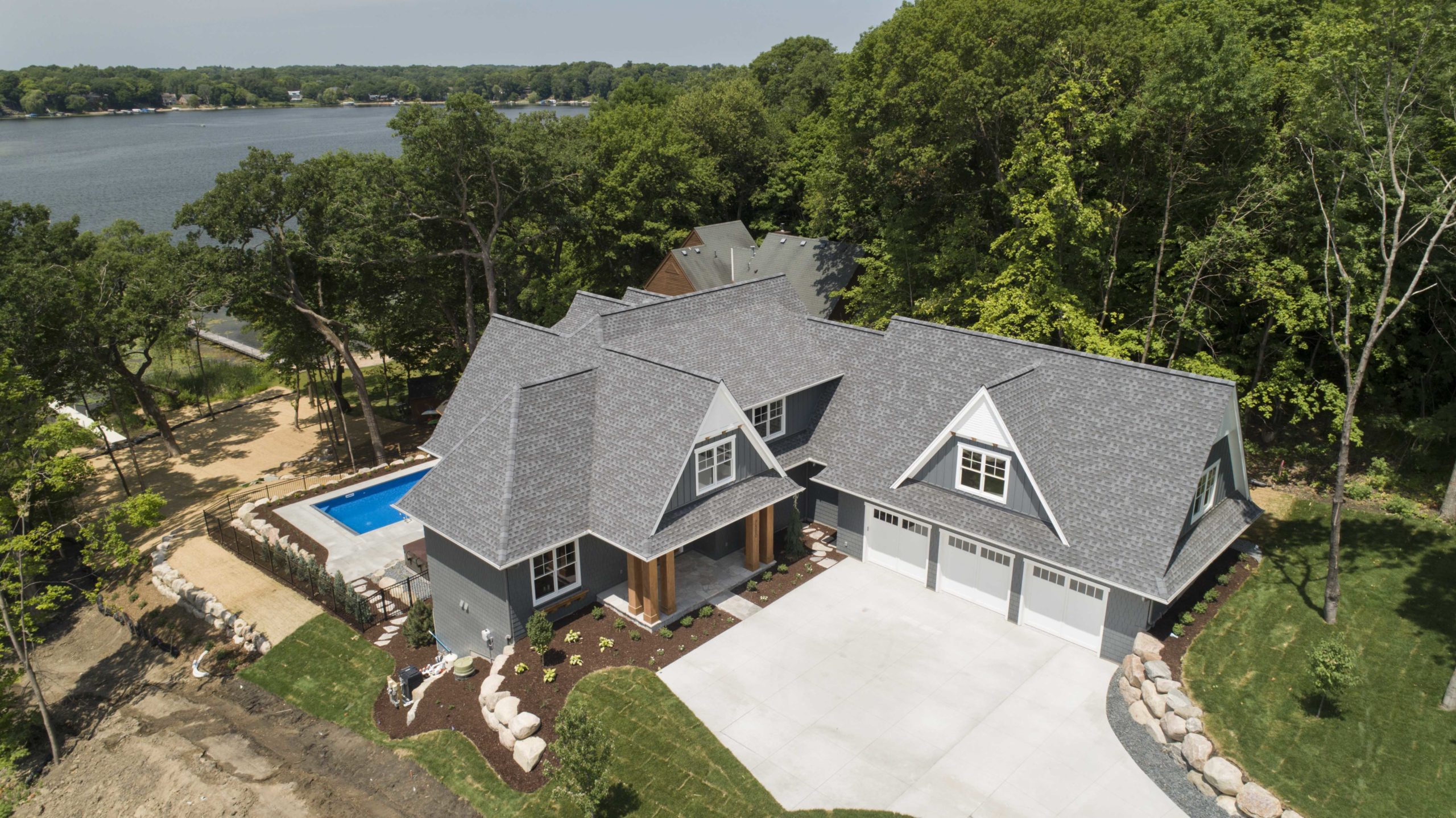 A custom lake home build with an aerial view near a tranquil lake.
