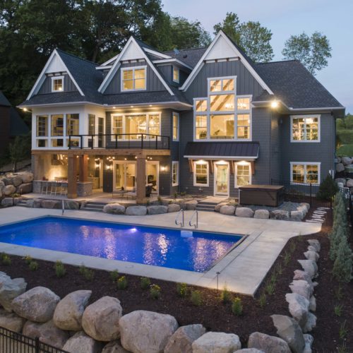 A custom lake home build with a swimming pool and landscaping.