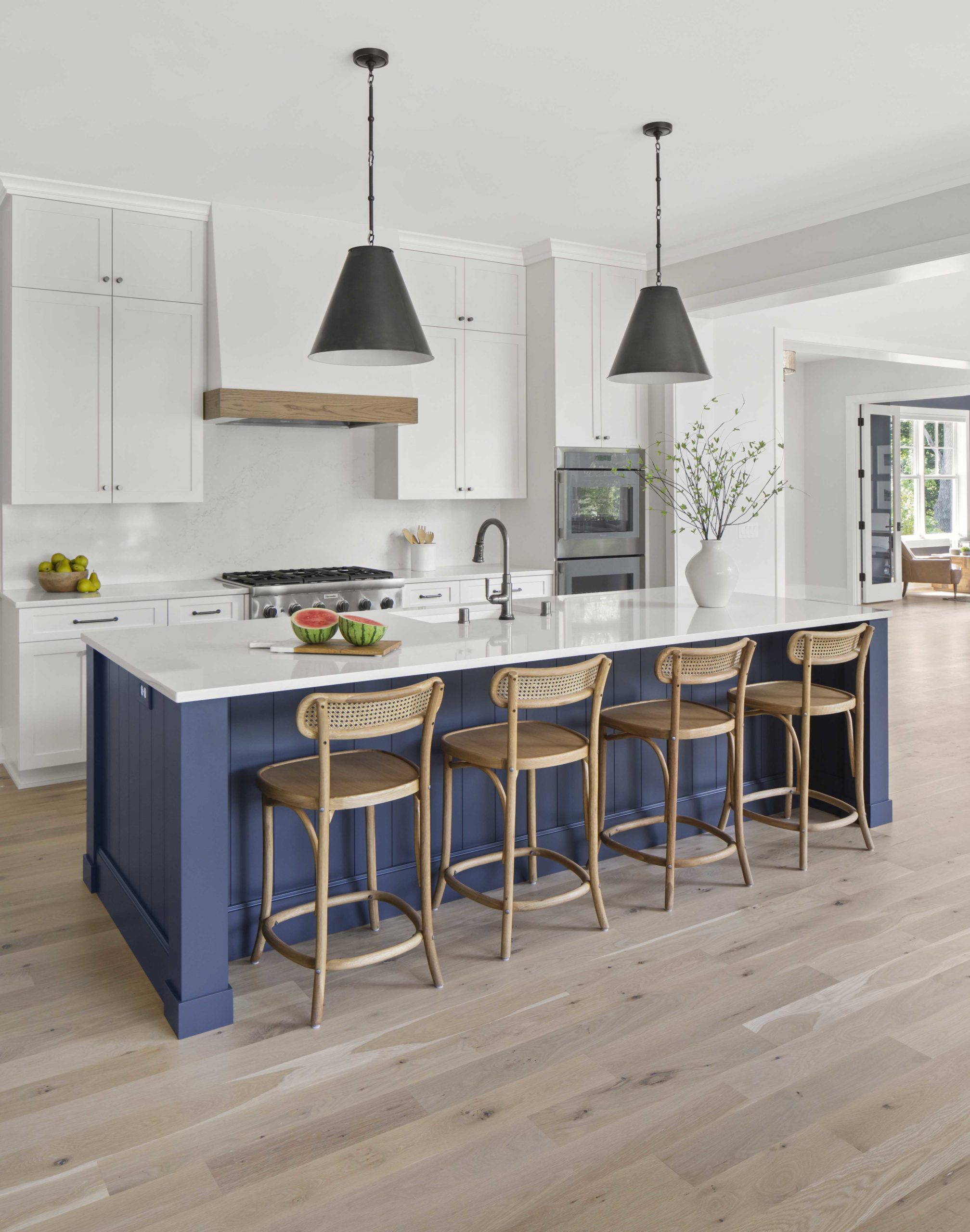 A custom lake home with a kitchen featuring a blue island and stools.