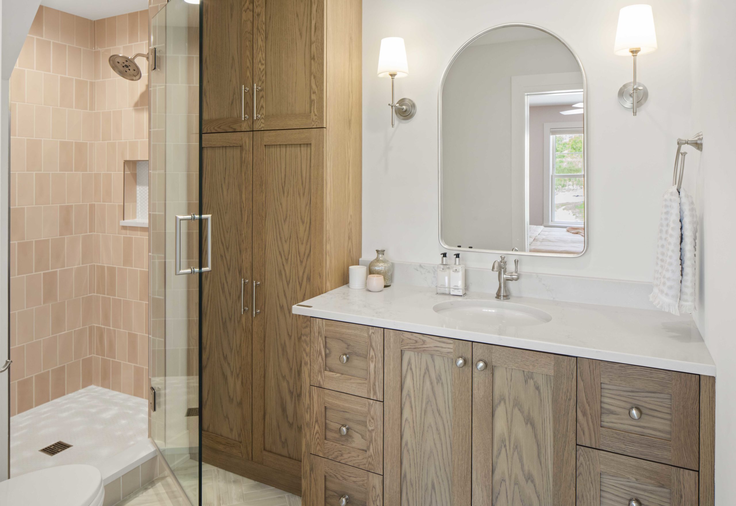A custom lake home bathroom with wooden cabinets and a glass shower.