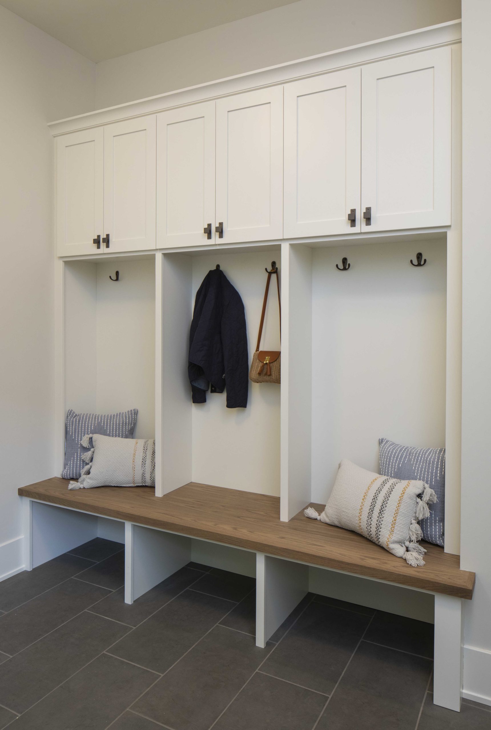 Custom lake home build: A mudroom with a bench and storage cabinets.