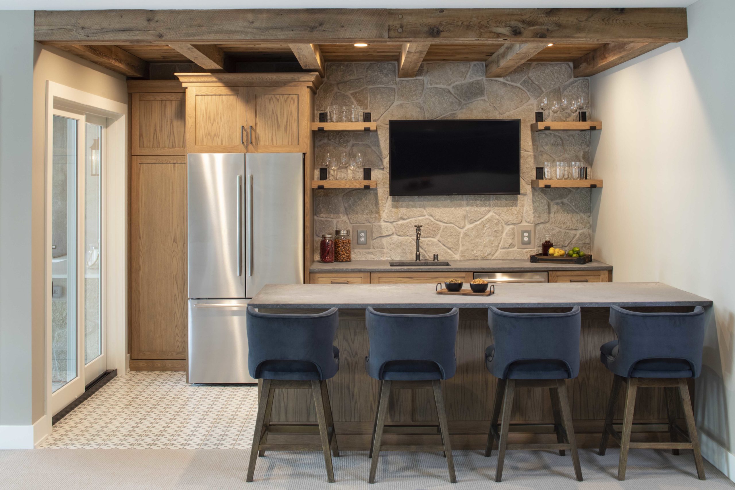 A small kitchen with custom lake home build featuring a bar stools and a TV.