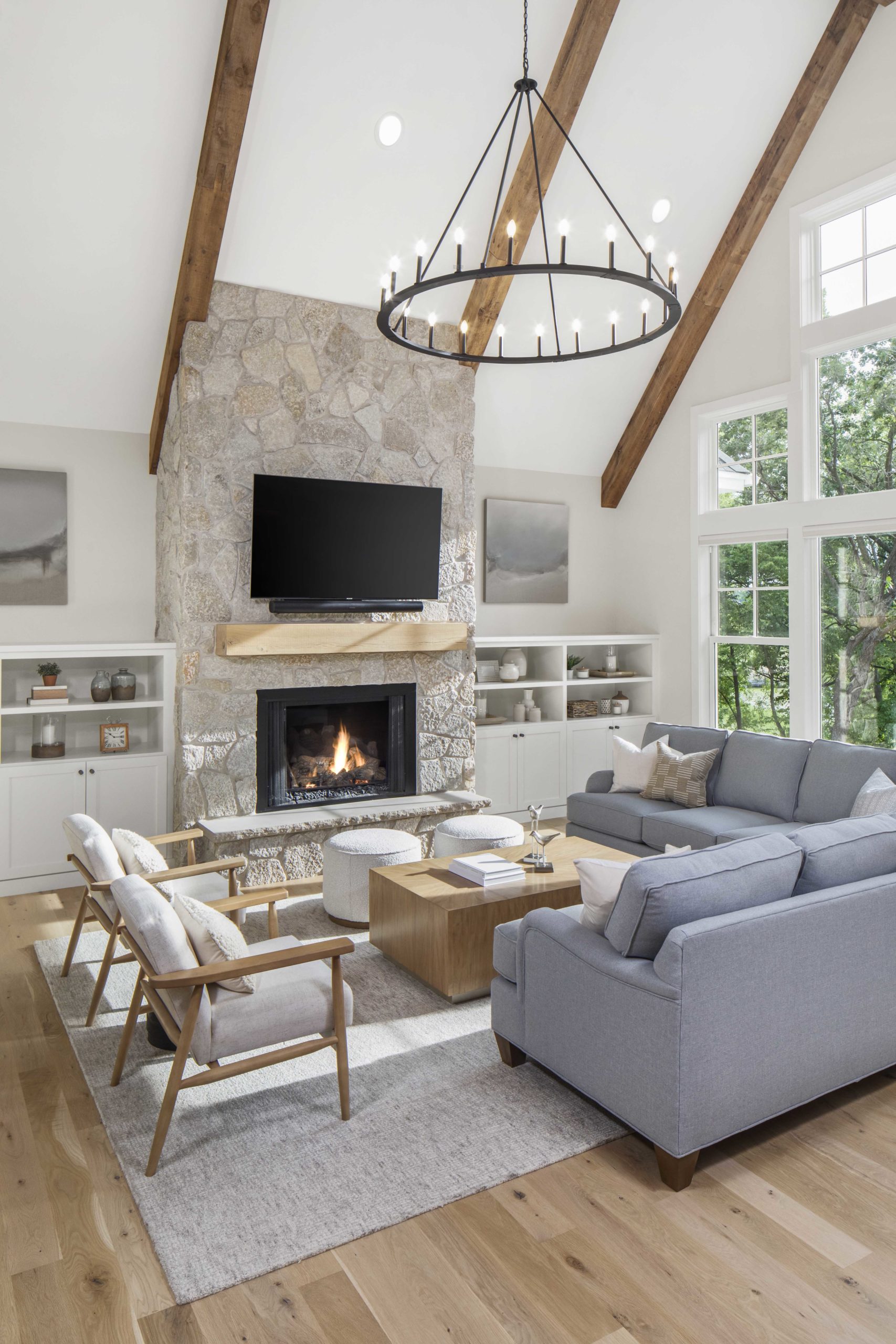 A custom lake home build featuring a large living room with wood beams and a fireplace.
