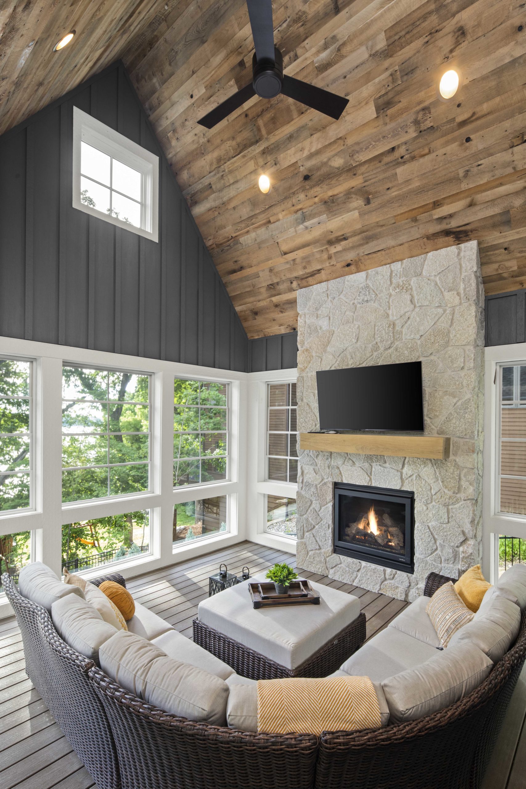 A custom lake home build with a living room featuring a wood ceiling and a fireplace.