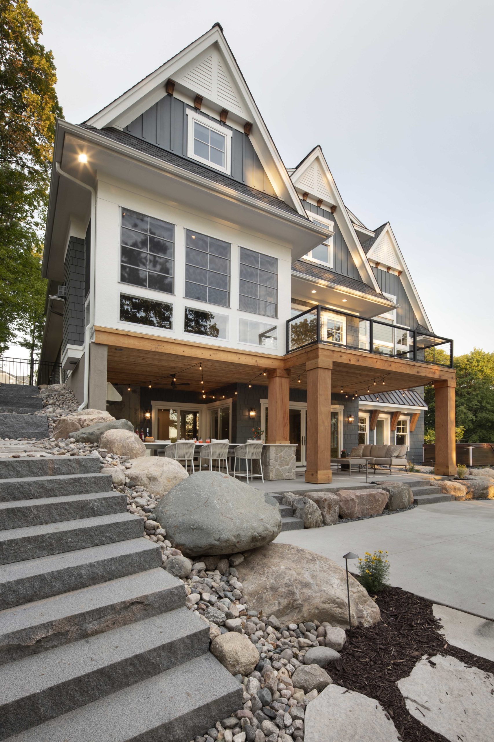 A custom lake home with a modern design, featuring a stone patio and steps.