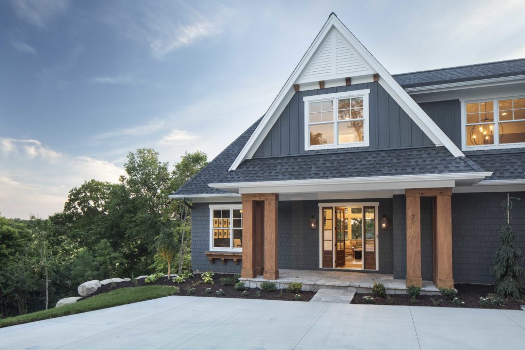 A custom lake home build, featuring a stunning exterior with gray siding and white trim.