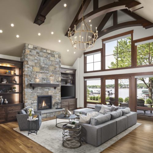 A spacious living room with a fireplace and large windows, perfect for a custom home remodel.