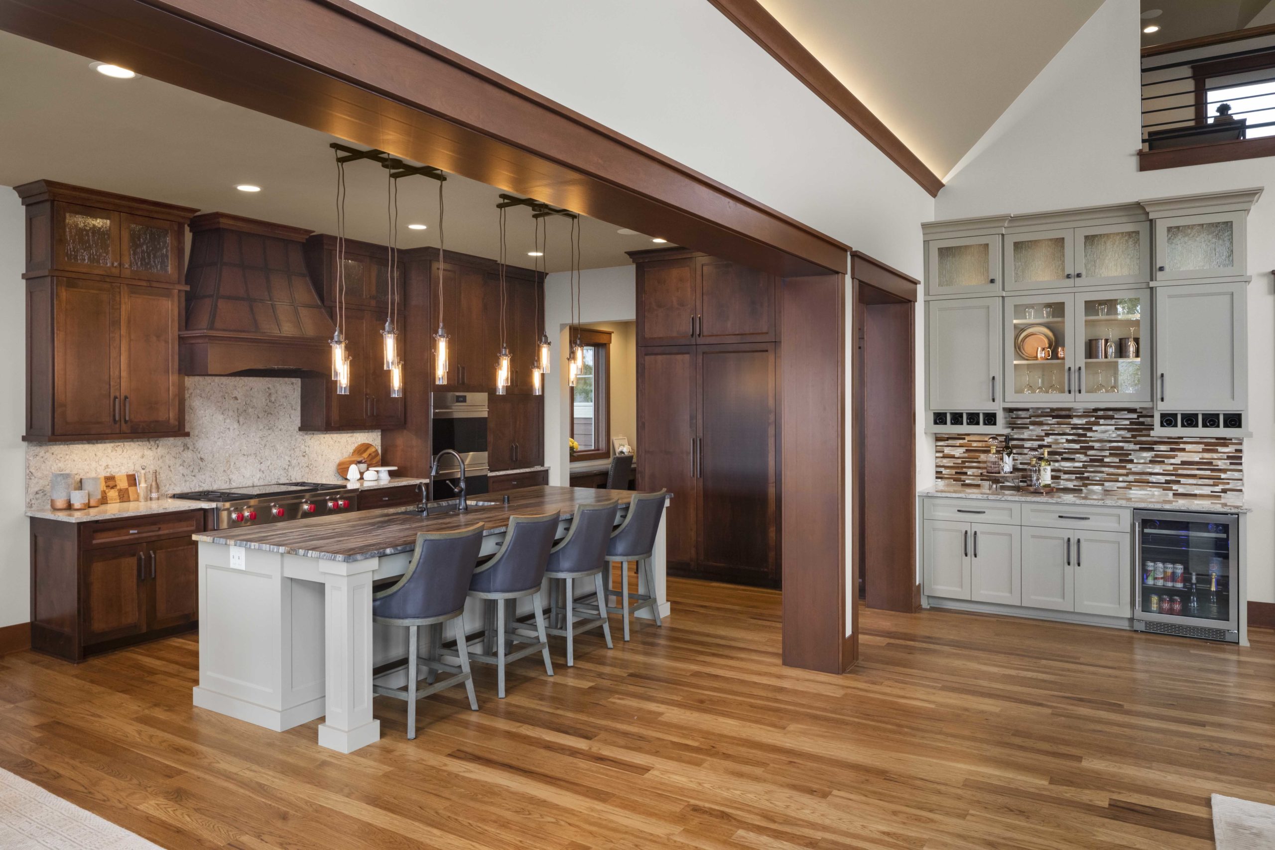 A custom home remodel featuring a large kitchen with wood floors and a center island.