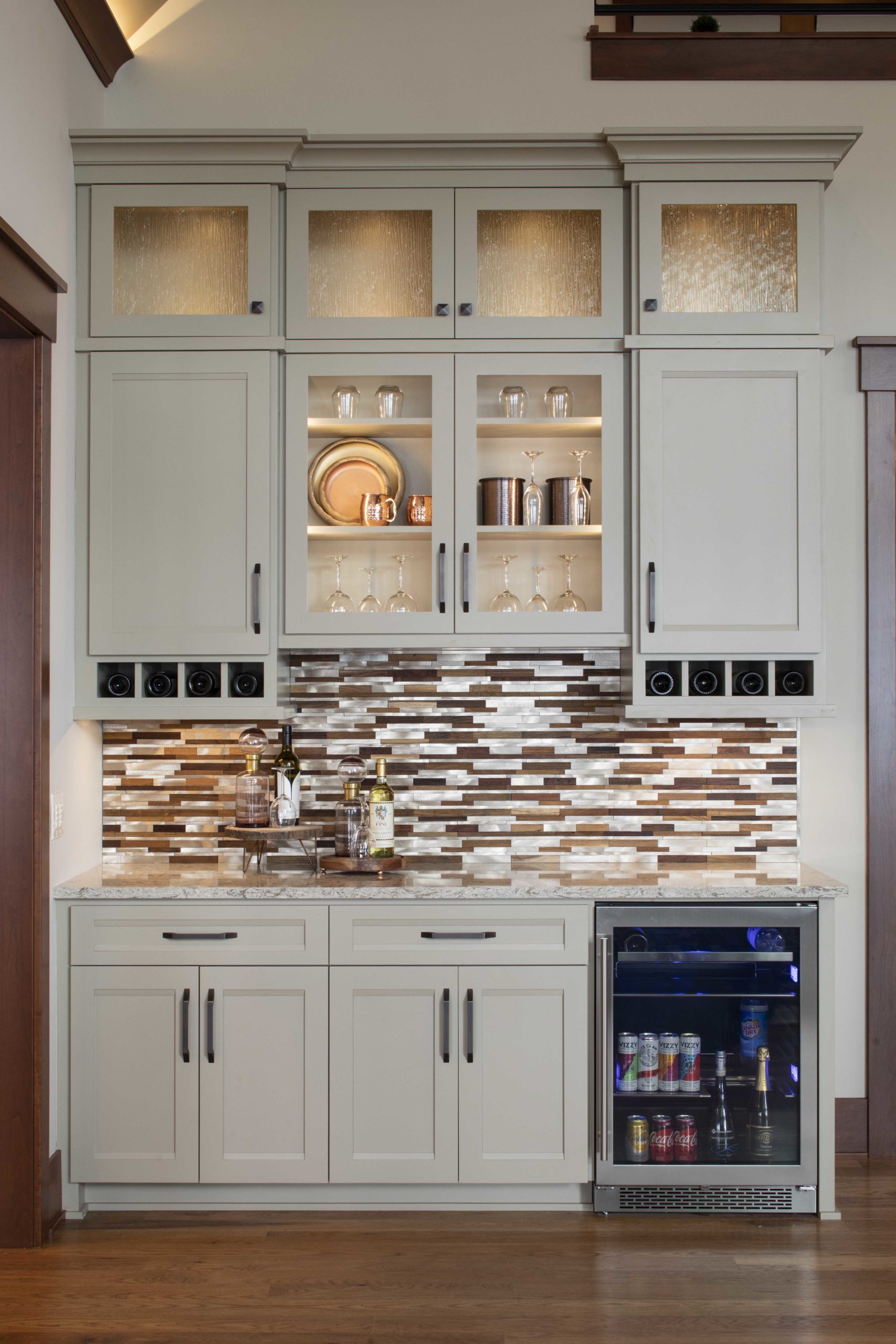 A kitchen with white cabinets and a custom home remodel, including a refrigerator.