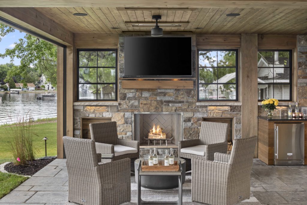 A custom home remodel featuring an outdoor living area with a fireplace and tv.