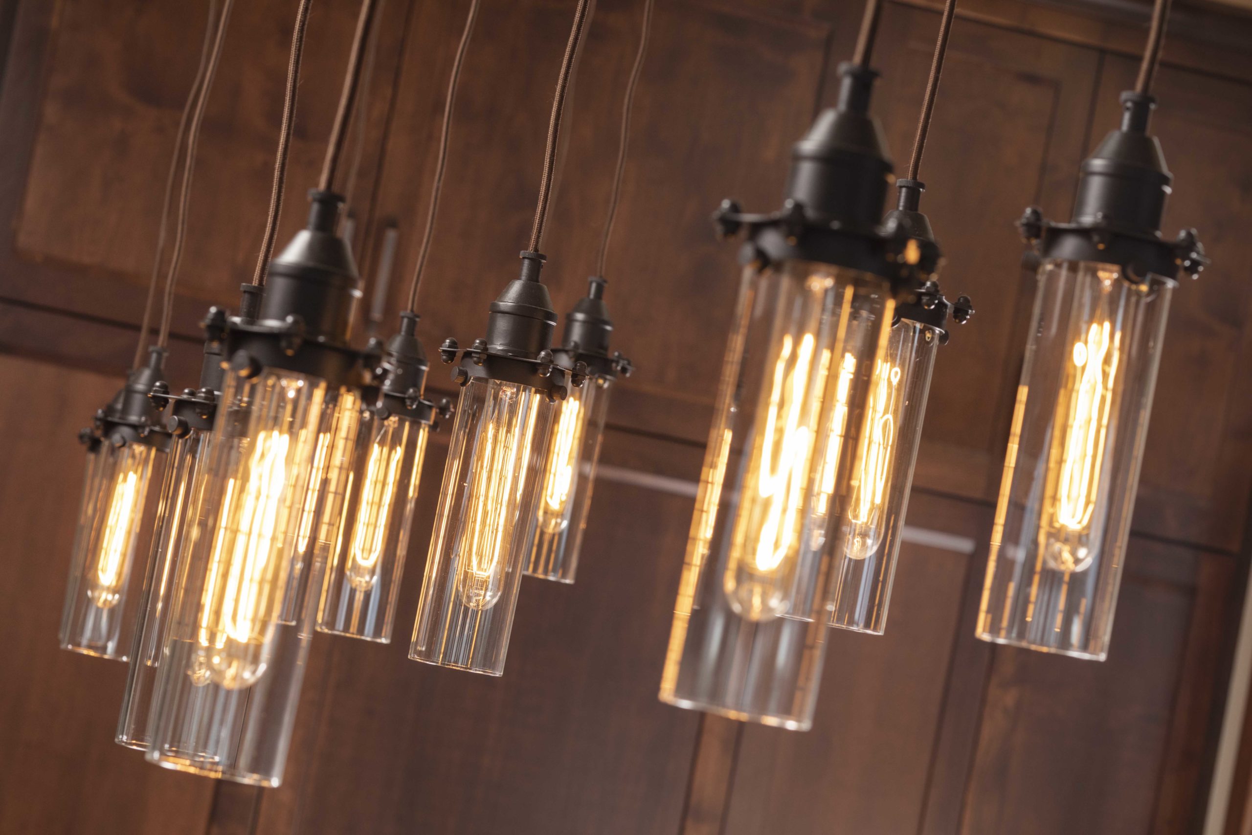 A group of pendant lights hanging from a custom home remodel's wooden ceiling.