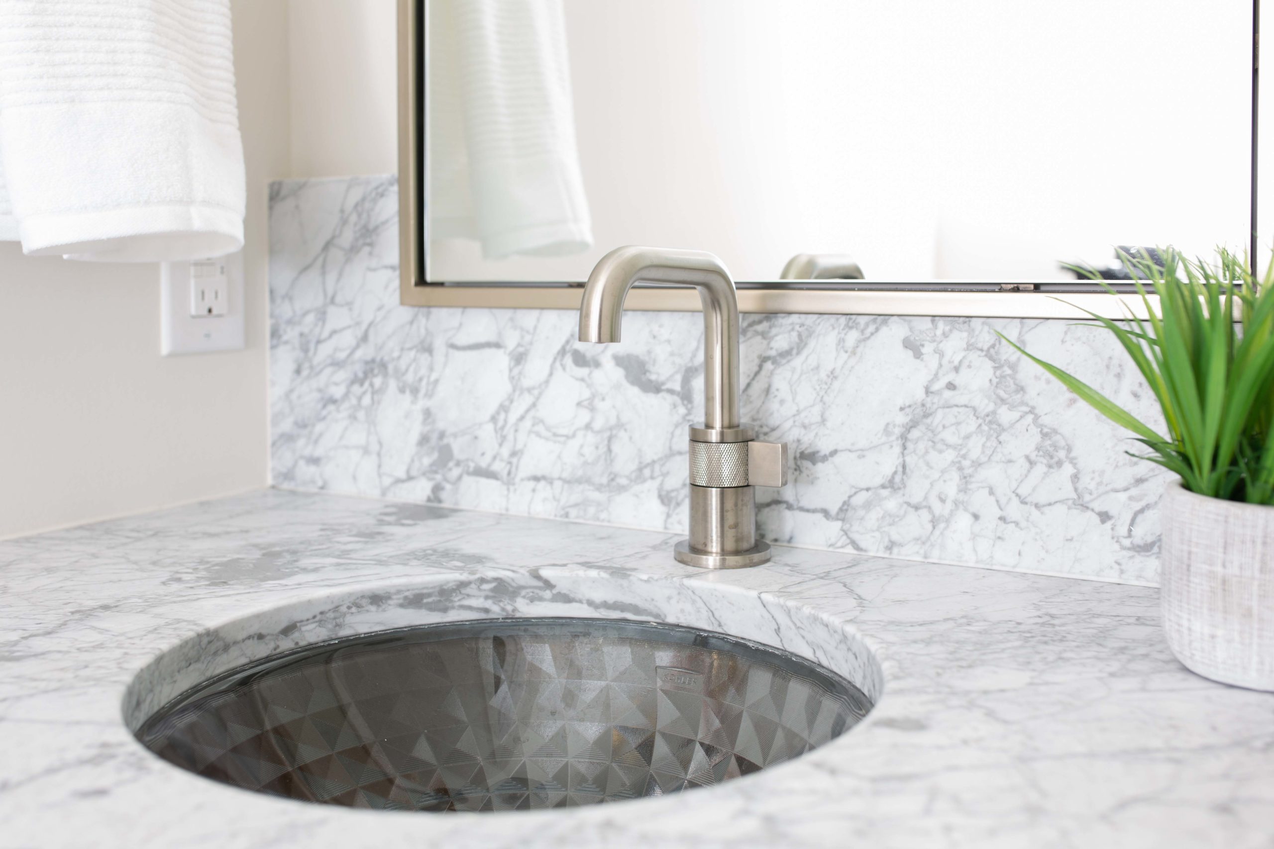 A modern bathroom sink with a marble countertop in a lake home build.