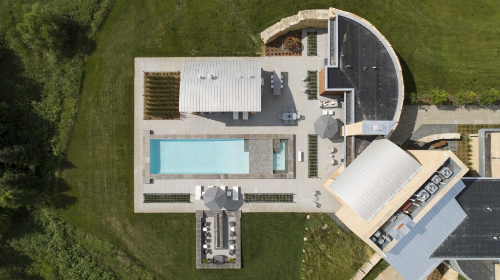 An contemporary farmhouse with a swimming pool.