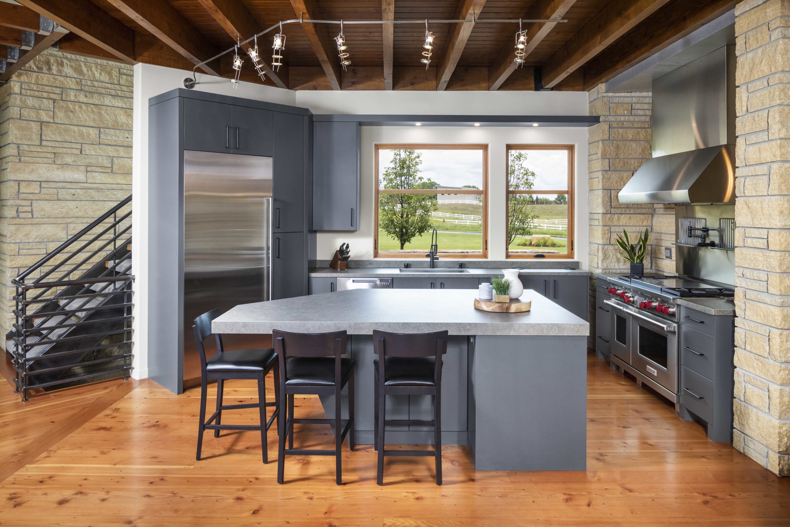 In this contemporary farmhouse kitchen, you will find sleek wood floors and a spacious center island.