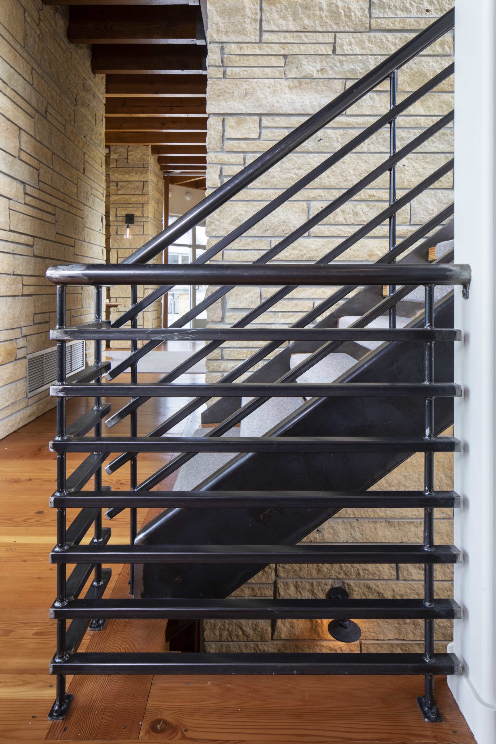 A contemporary staircase with a metal railing.