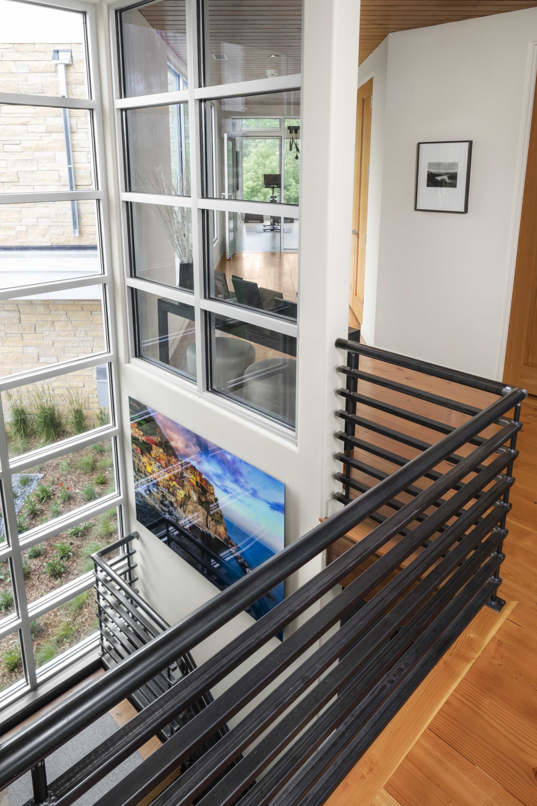 A contemporary staircase with a black railing and a large picture