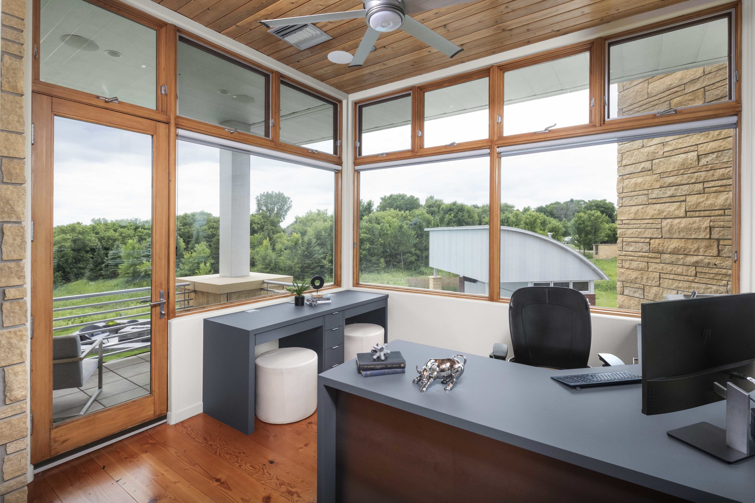 A contemporary home office with a large window and a desk.